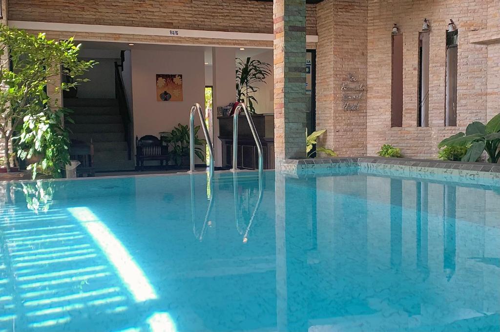 una piscina de agua azul frente a un edificio en Ice Kamala Beach Hotel, en Kamala Beach