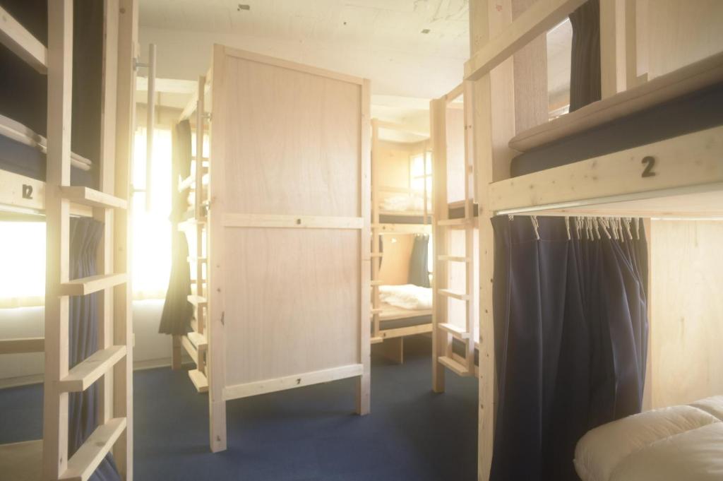 a dorm room with bunk beds and a bed at Wharf Inn in Yokohama
