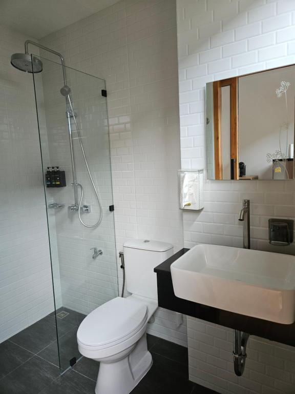 y baño con aseo, lavabo y ducha. en RINA Poolvilla (รินะ พูลวิลล่า) en Hat Yai