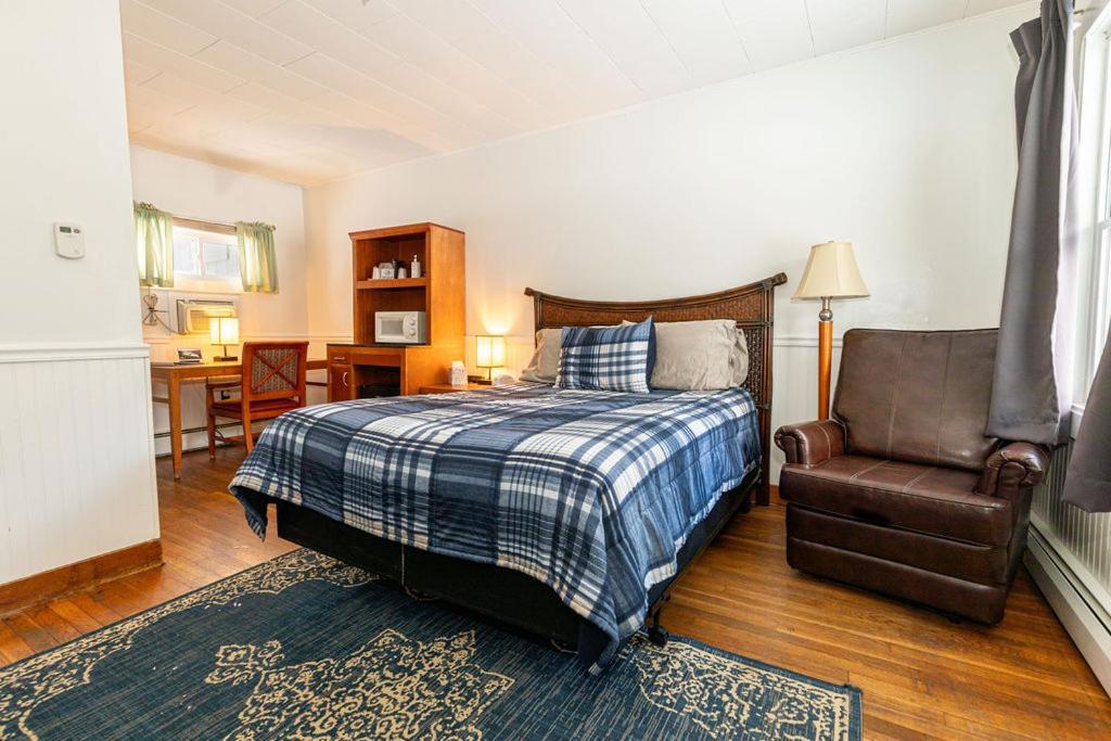 a bedroom with a bed and a chair at West Bethel Motel in Bethel