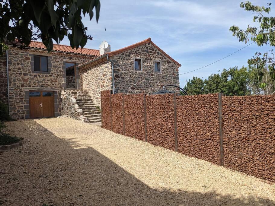 una cerca de ladrillo frente a una casa en Maison de Vacances L'Etable, en Saint-Just-près-Brioude