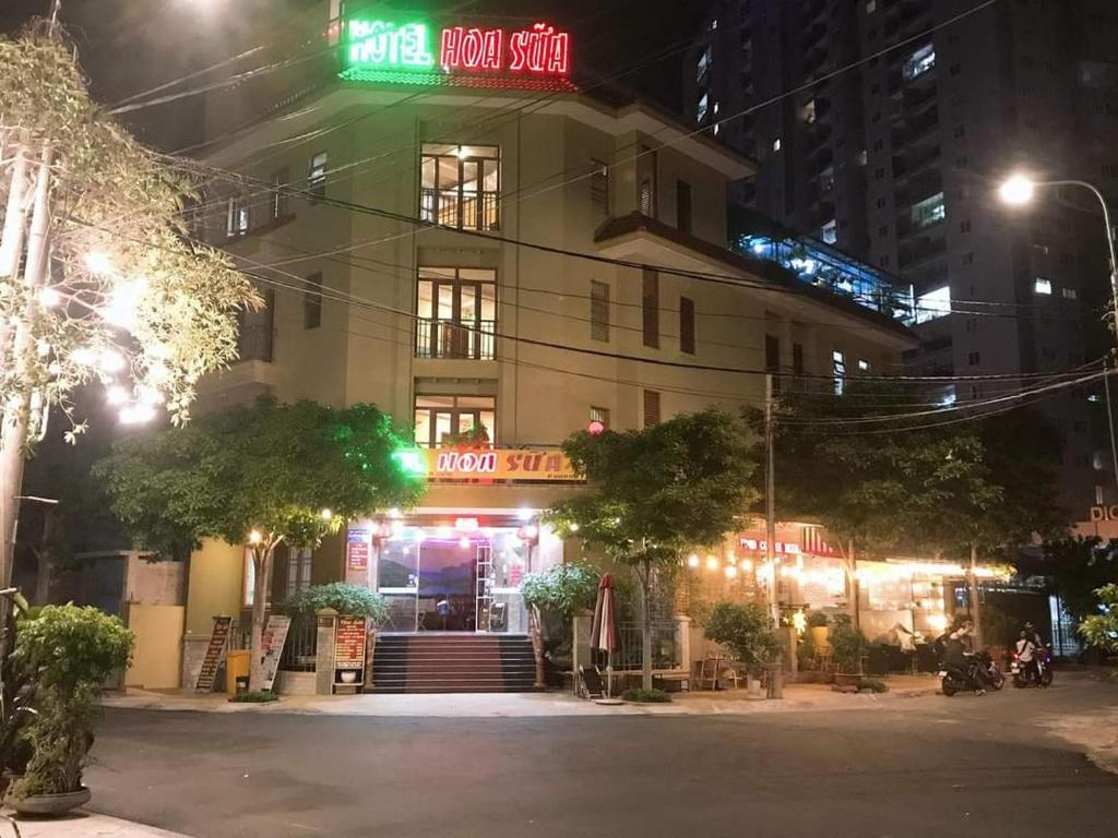 ブンタウにあるHoa Sua Hotelの前面にネオンの看板が立つ建物