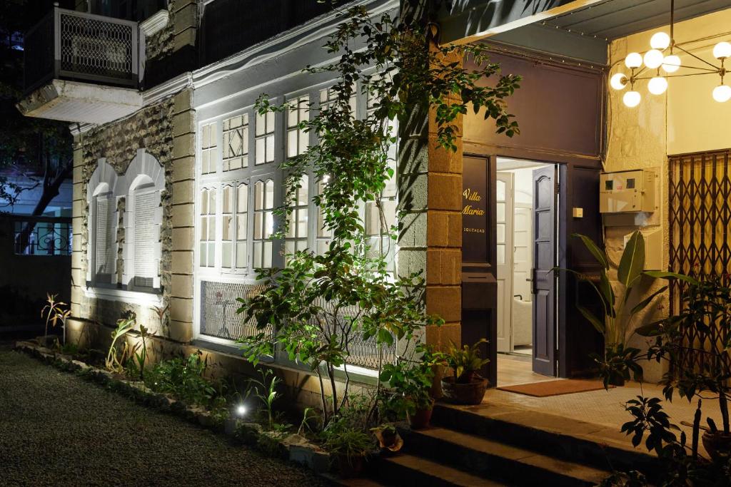 a house with a lit up facade at night at Souzagad - Villa Maria in Pune