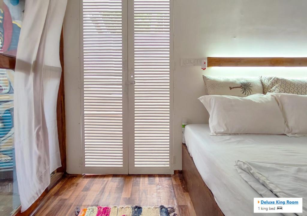 een slaapkamer met een bed en een groot raam bij Palolem Hideout in Canacona
