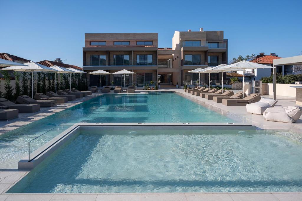 una grande piscina con sedie e un edificio di Oniro Boutique Hotel a Toroni