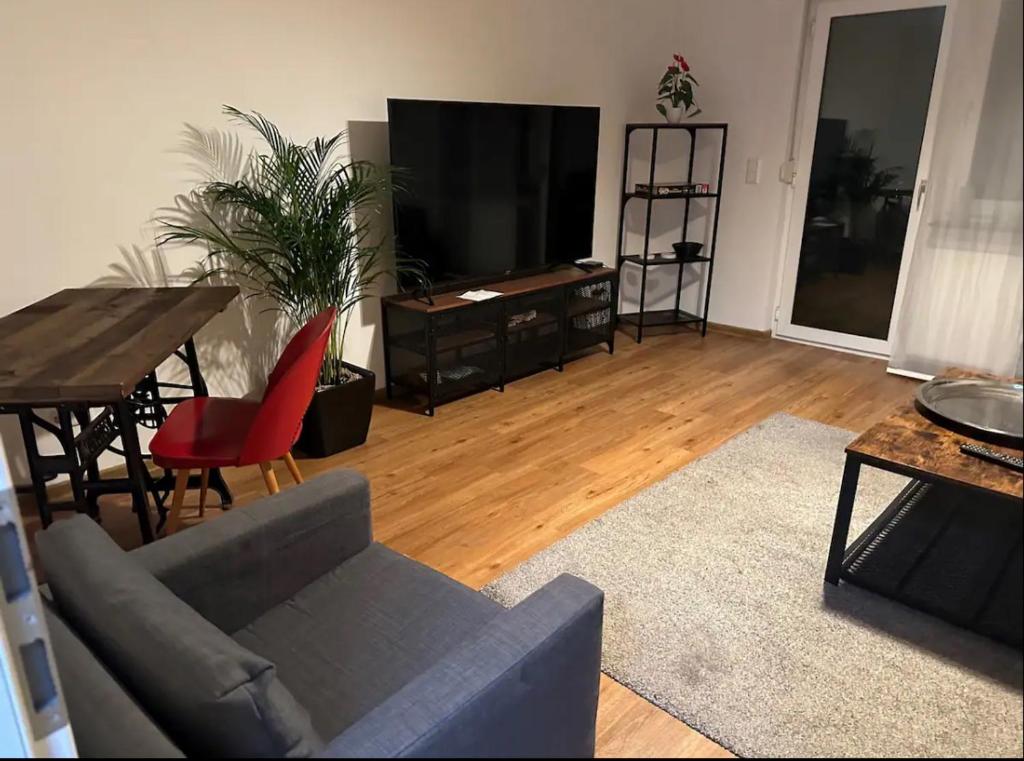 a living room with a couch and a table and a television at Apartment Roomy Comfort - Zwischen Heidelberg und Mannheim in Edingen-Neckarhausen