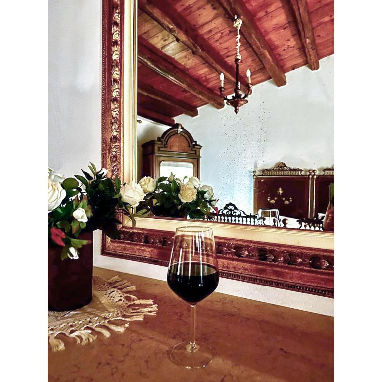 a glass of wine sitting on a table in a room at Casa Al Plumbago in Termini Imerese