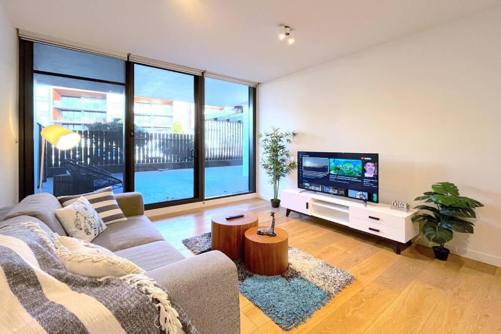 a living room with a couch and a flat screen tv at Brilliant Quay Blvd Apt Close to Wyndham Harbour in Werribee South