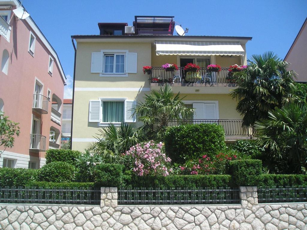 un edificio con fiori e piante di fronte di Family Apartments Ankica a Crikvenica