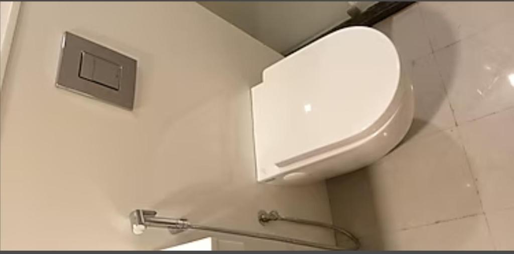 a bathroom with a white toilet in a wall at Hotel M in Vijayawāda