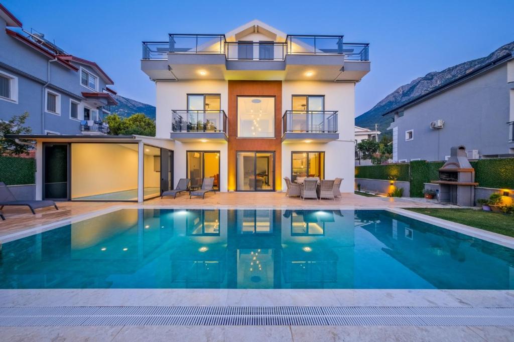 una casa con piscina frente a una casa en Villa Lotus Sea, en Fethiye