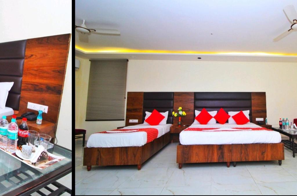 2 łóżka w pokoju hotelowym z czerwonymi poduszkami w obiekcie HOTEL HANUWANT AIRPORT 7 Minutes Distance From IGI AIRPORT 3 Minutes From Aero City Metro Station Book Now For More Offers w Nowym Delhi