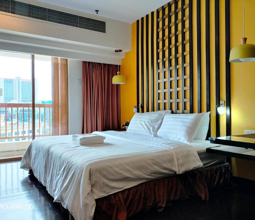 Schlafzimmer mit einem großen weißen Bett und einem Schreibtisch in der Unterkunft Sunway Resort Suites@Sunway Pyramid and Sunway Lagoon in Kampong Penaga