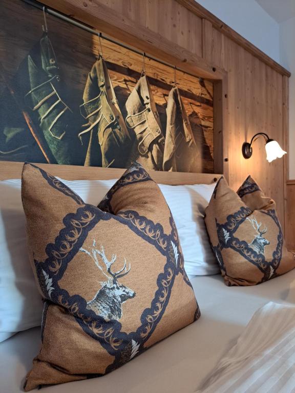 Una cama con almohadas con un ciervo. en Stauders Zimmer und Ferienwohnungen, en Innsbruck