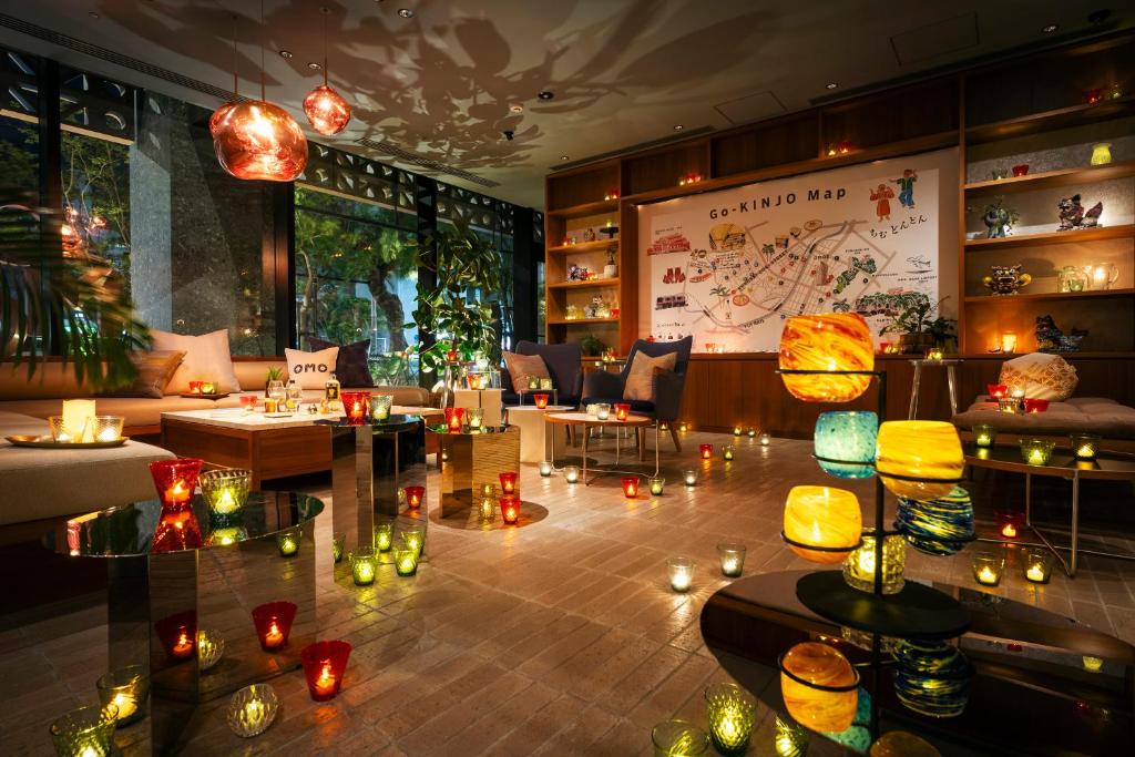 那霸的住宿－OMO5 Okinawa Naha by Hoshino Resorts，一间设有蜡烛的地板、桌子和椅子的房间