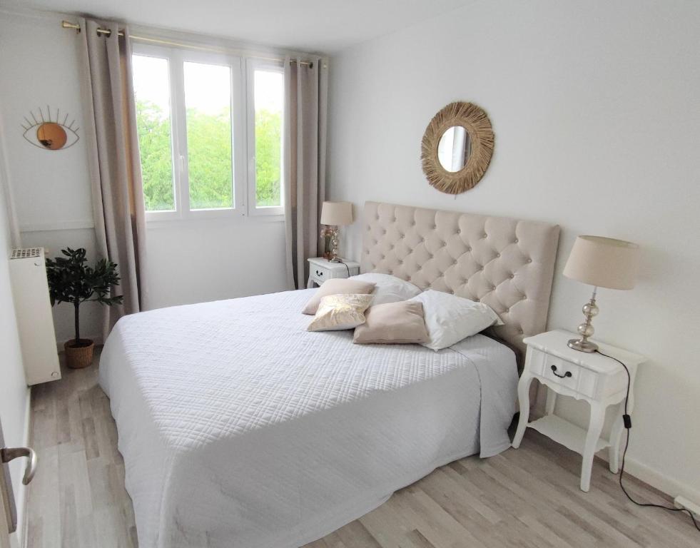 a white bedroom with a white bed and a mirror at Bel appartement entre Disney Land et Paris in Chelles