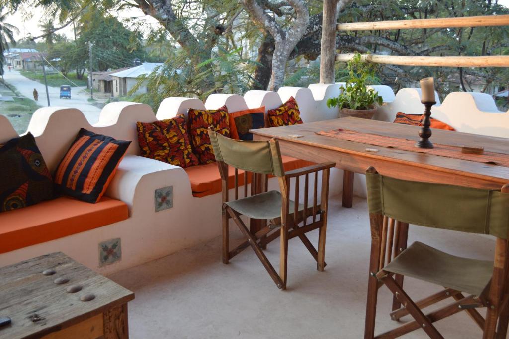 eine Terrasse mit einem Sofa, einem Tisch und Stühlen in der Unterkunft Ella's Swahili House in Bagamoyo