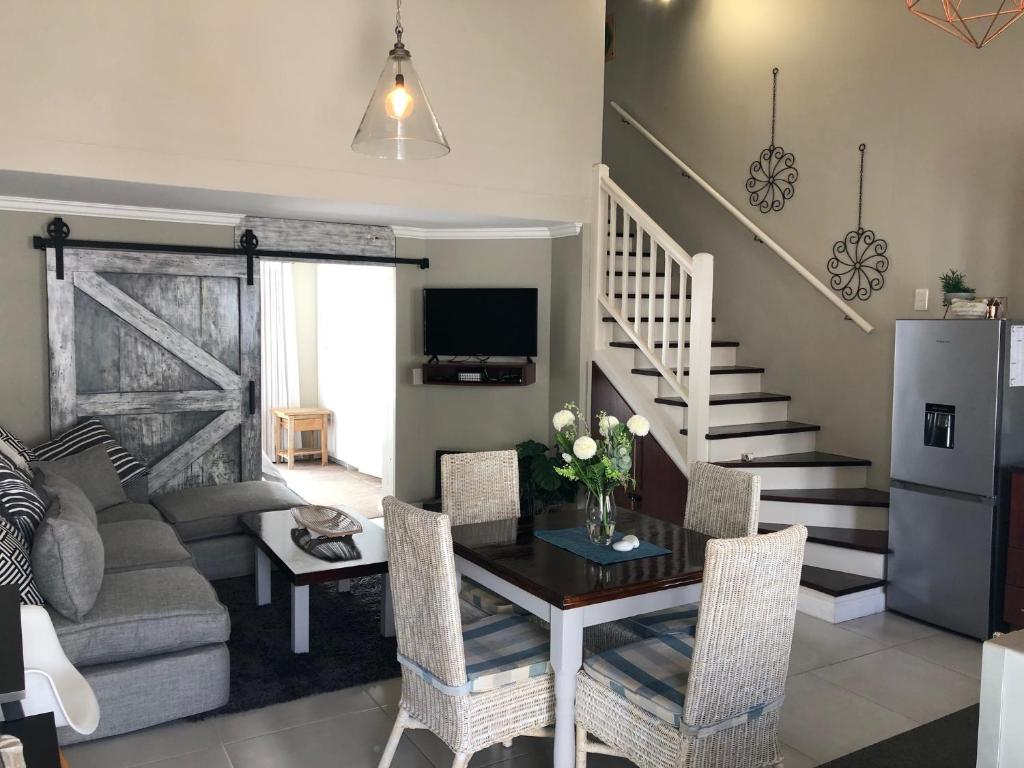 a living room with a couch and a table with chairs at 19 Lagoon Terrace in Knysna