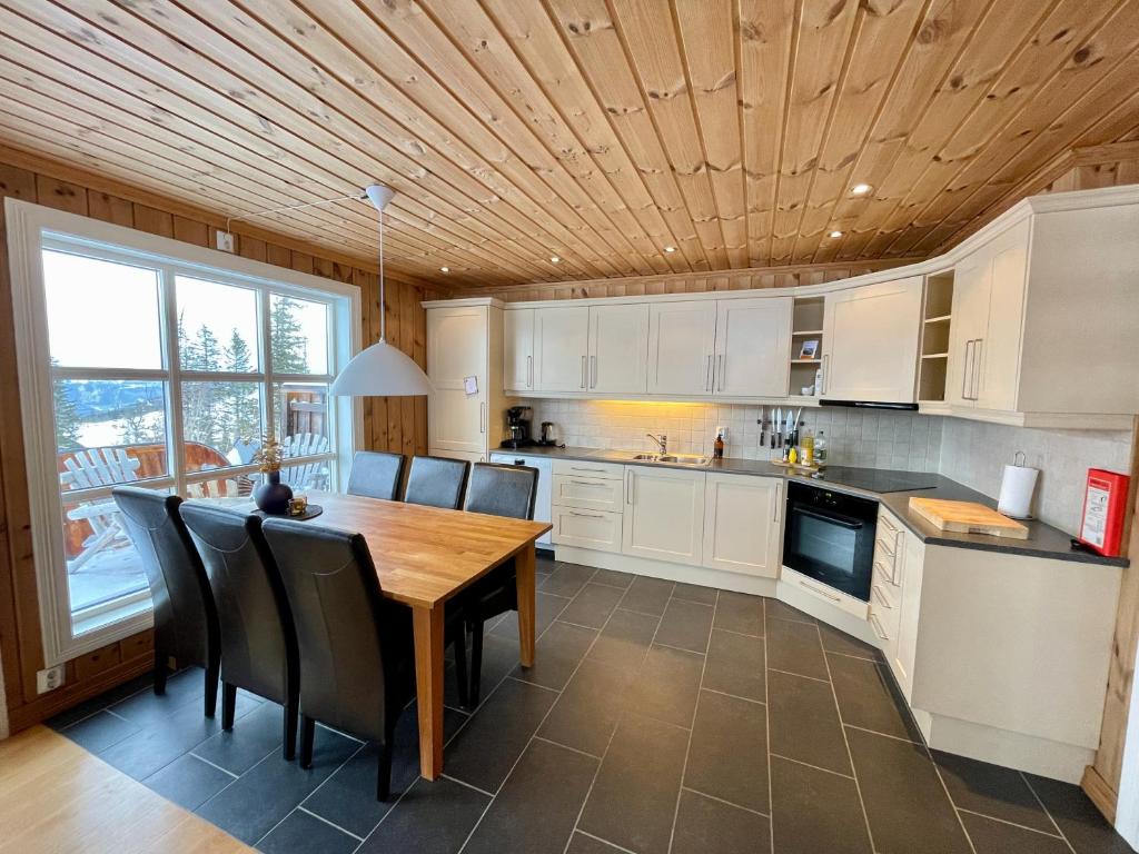 a kitchen with a wooden ceiling and a wooden table at Gausta Lodge med 6 sengeplasser i nærhet til Gaustatoppen in Gaustablikk
