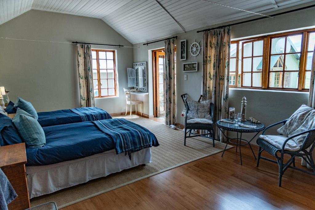 a bedroom with a bed and a table and chairs at Tafeni Farm Cottages in Swartberg