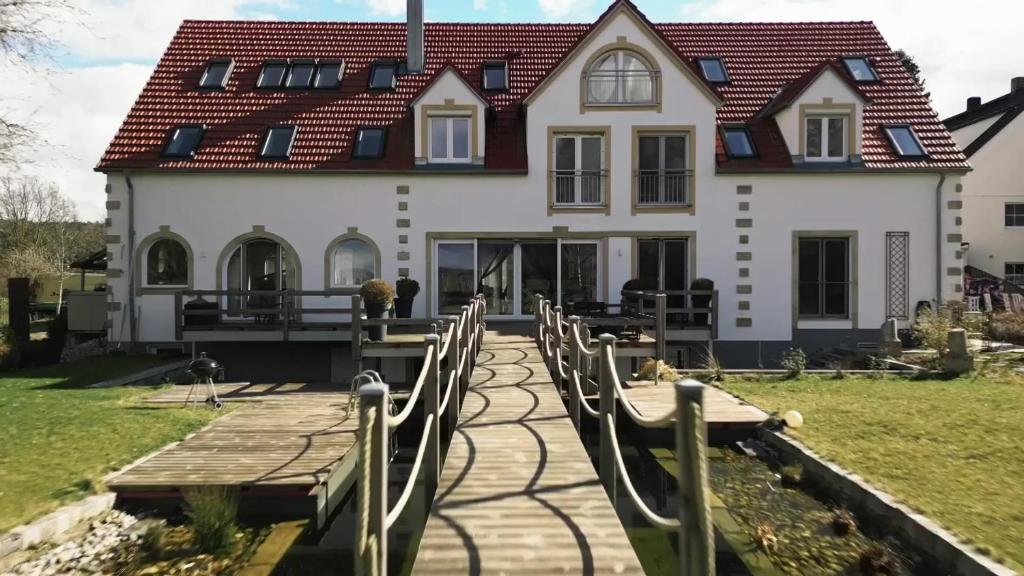 een huis met een houten loopbrug ervoor bij Berg-Hof in Pfaffenhofen an der Ilm