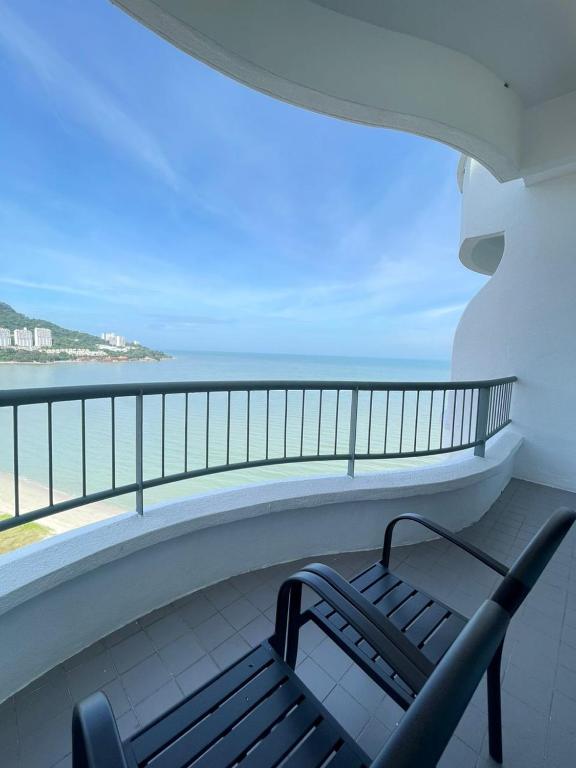 a bench on a balcony with a view of the ocean at Flamingo Hotel by the Beach, Penang in George Town