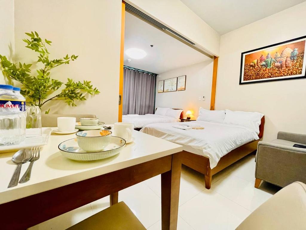 a hotel room with a bed and a table with dishes on it at Thompson Suites - 2 beds, One Uptown Residences 28F A - XBOX & Netflix in Manila
