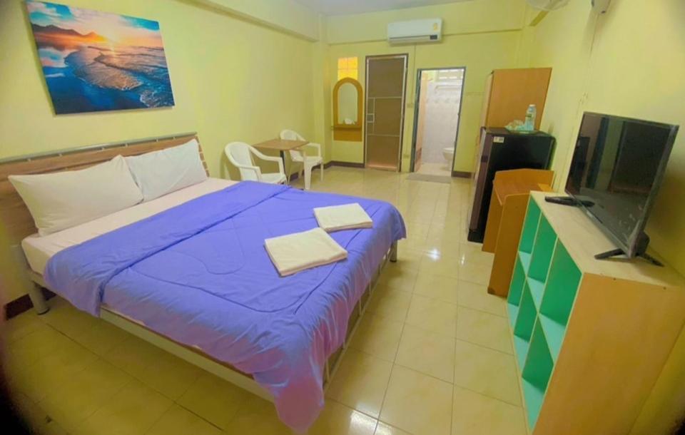 a bedroom with a large bed and a television at DD Mansion in Ban Talat Rangsit