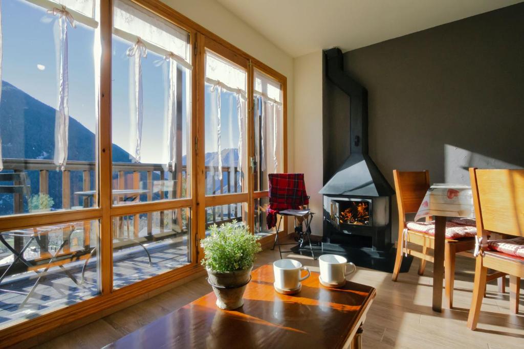 sala de estar con mesa y chimenea en Apartamento La Ginesta 2, en Taüll