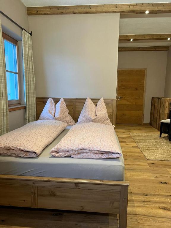 a bed with pillows on it in a room at Zimmer in Kirchberg in Tirol in Kirchberg in Tirol