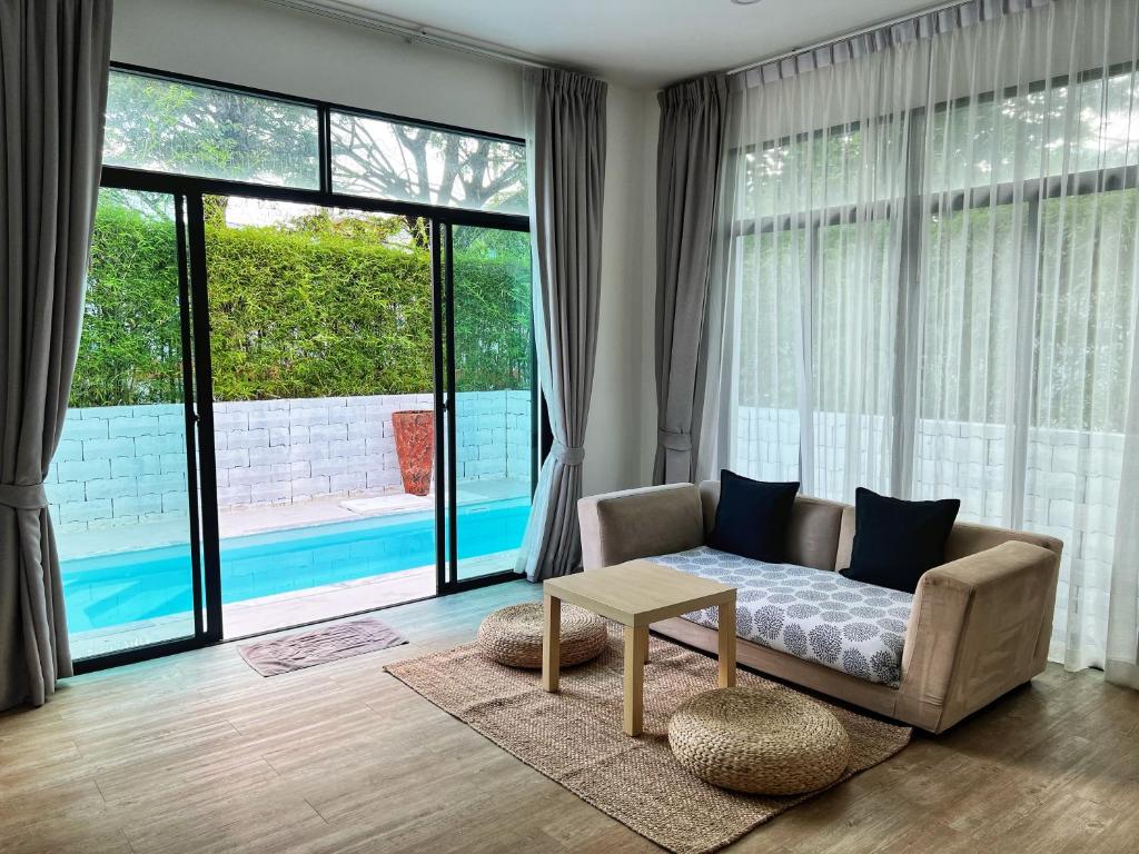 a living room with a couch and a table at Ida Japanese pool villa in Chalong 