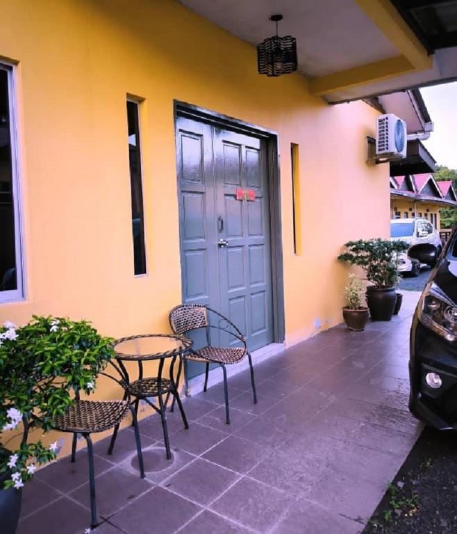 a patio with two chairs and a table in front of a building at VILLA SERI MUTIARA in Kuah