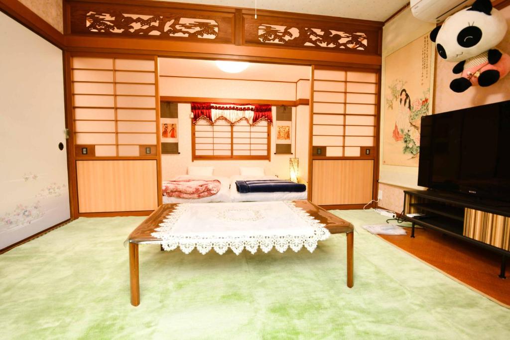 a room with a table in the middle of a room at 媛楽園 松山中心地及び道後温泉に近い家族やグループ旅行の多人数が泊まれる快適な宿 in Matsuyama