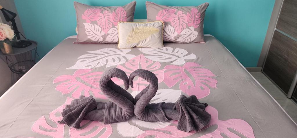 a bed with two black flamingos laying on it at Chez Eden Coconut Studio in Papeete