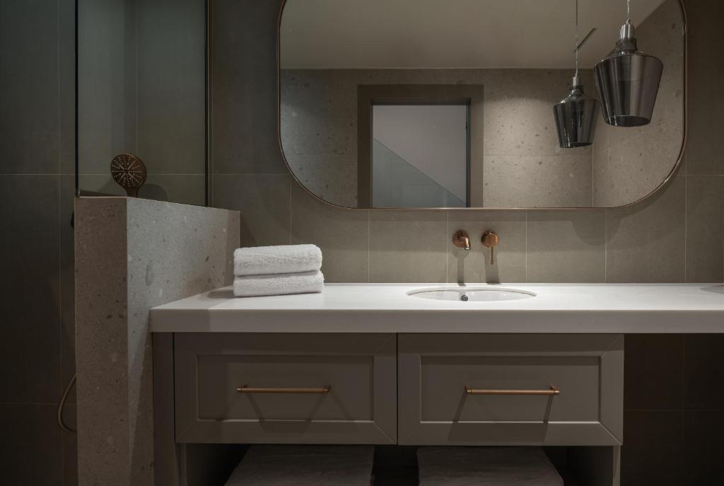 a bathroom with a sink and a mirror at Oniro Boutique Hotel in Toroni