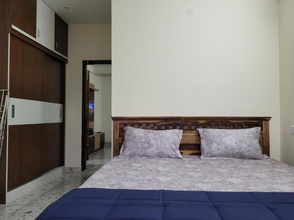 a bedroom with a large blue bed with two pillows at Castle Hebbal Service Apartments in Bangalore