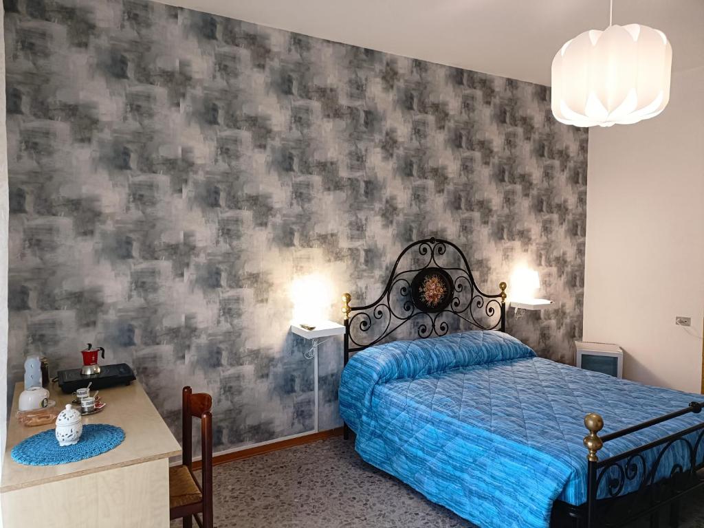 - une chambre avec un lit et une couette bleue dans l'établissement Domus Stadio, à Pescara