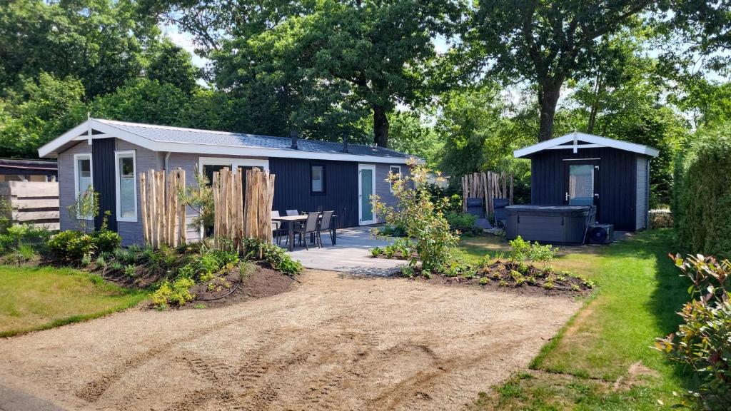 a blue caravan in a garden with a patio at TOP Spa 2+2 in Voorthuizen