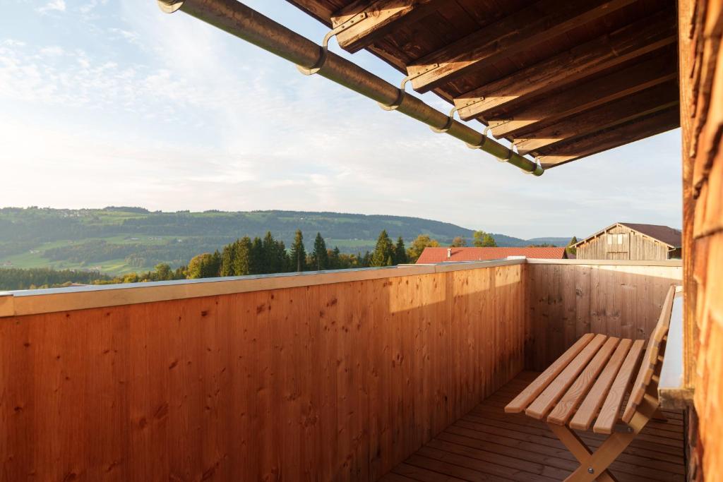 una terraza de madera con un banco sobre una valla de madera en Ferienwohnung Raid, en Riefensberg