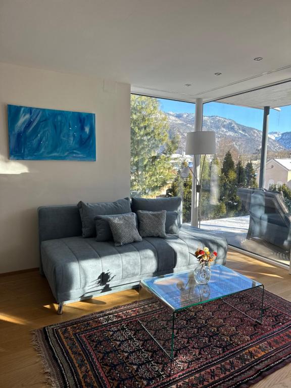 een woonkamer met een bank en een glazen tafel bij THE VIEW - Modern Panorama Residence in Bad Ischl