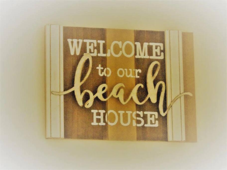 Una señal que dice bienvenida a nuestra casa de la playa en Bec's Beach House Getaway, en Batemans Bay