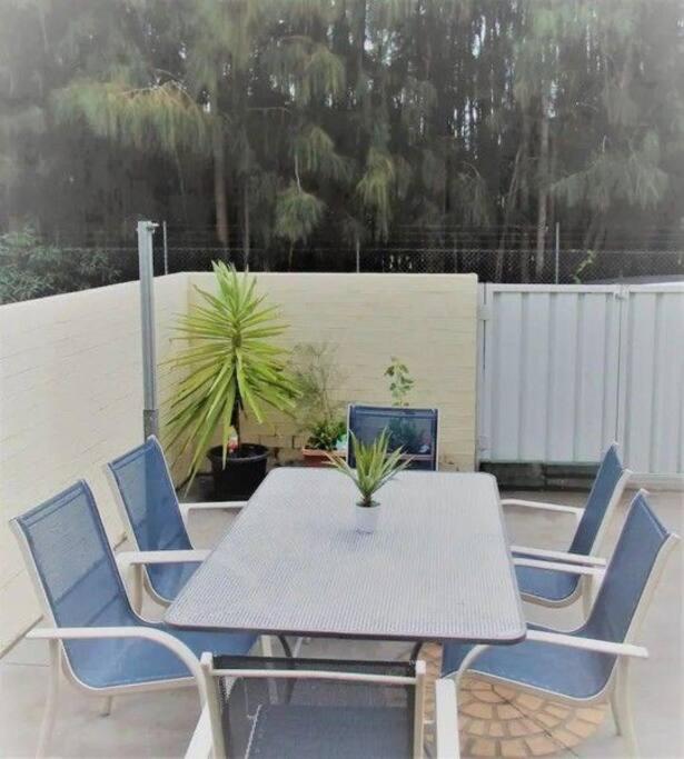 a table and chairs with a potted plant on a patio at Bec's Beach House Getaway in Batemans Bay