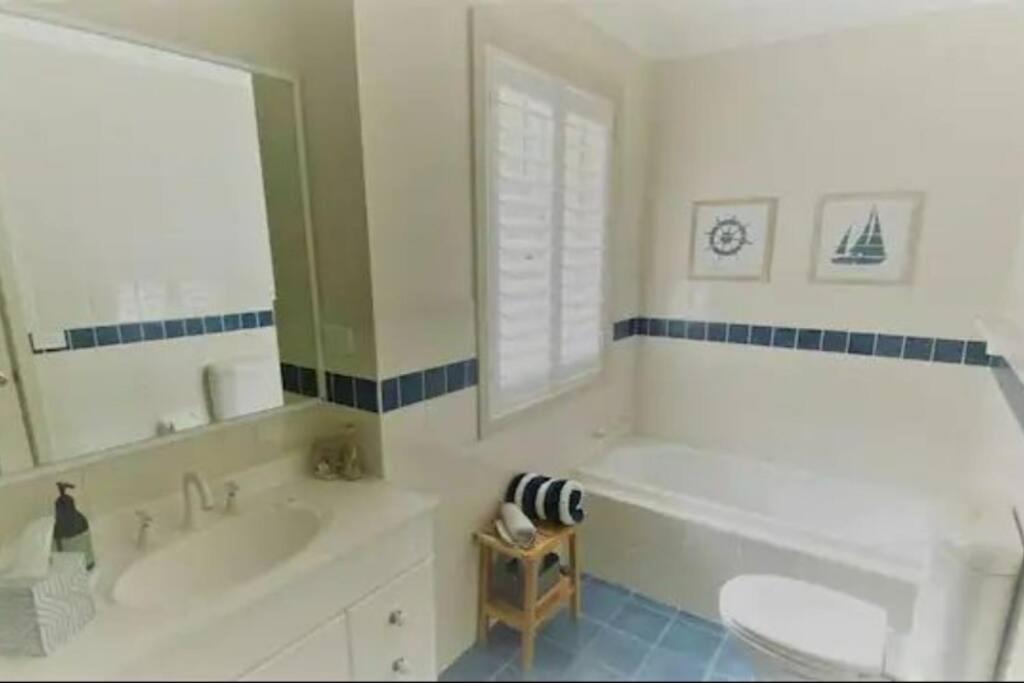 a bathroom with a tub and a toilet and a sink at Bec's Beach House Getaway in Batemans Bay