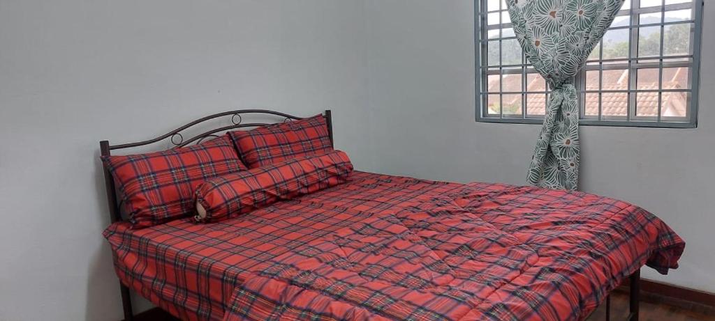 史里肯邦安的住宿－LOTUS HOMESTAY，一间卧室配有红色的床、红色枕头和窗户