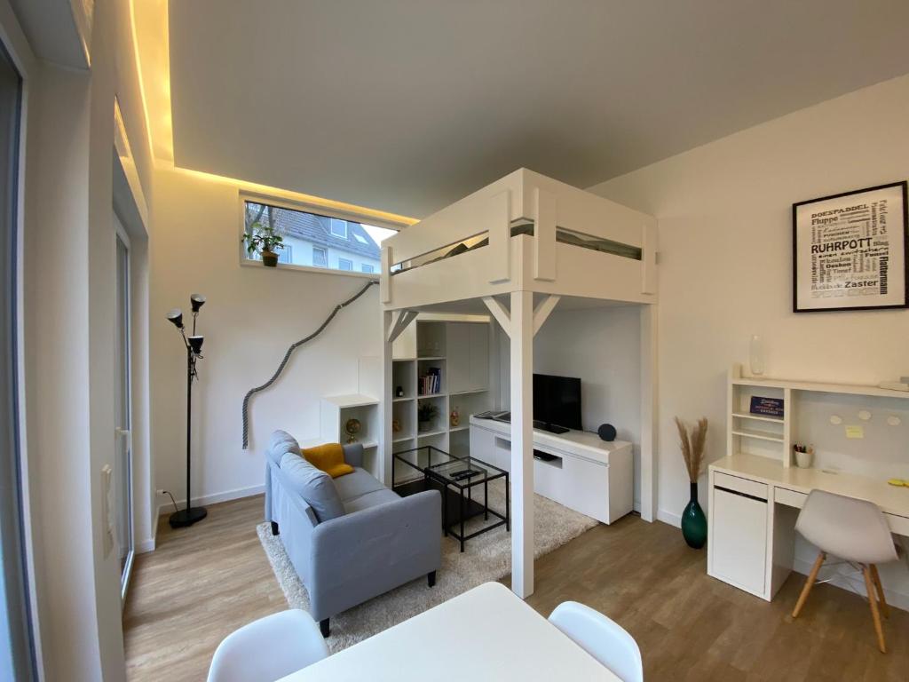 sala de estar con cama elevada y escritorio en Schöne, moderne Wohnung mit großzügiger Terasse, en Essen
