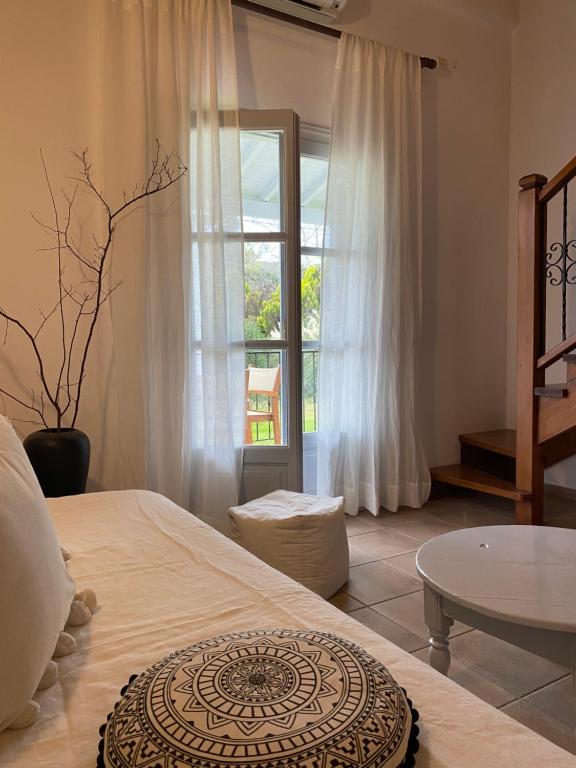 - une chambre avec un lit, une table et une fenêtre dans l'établissement Calma Cottage, à Skiathos Chora