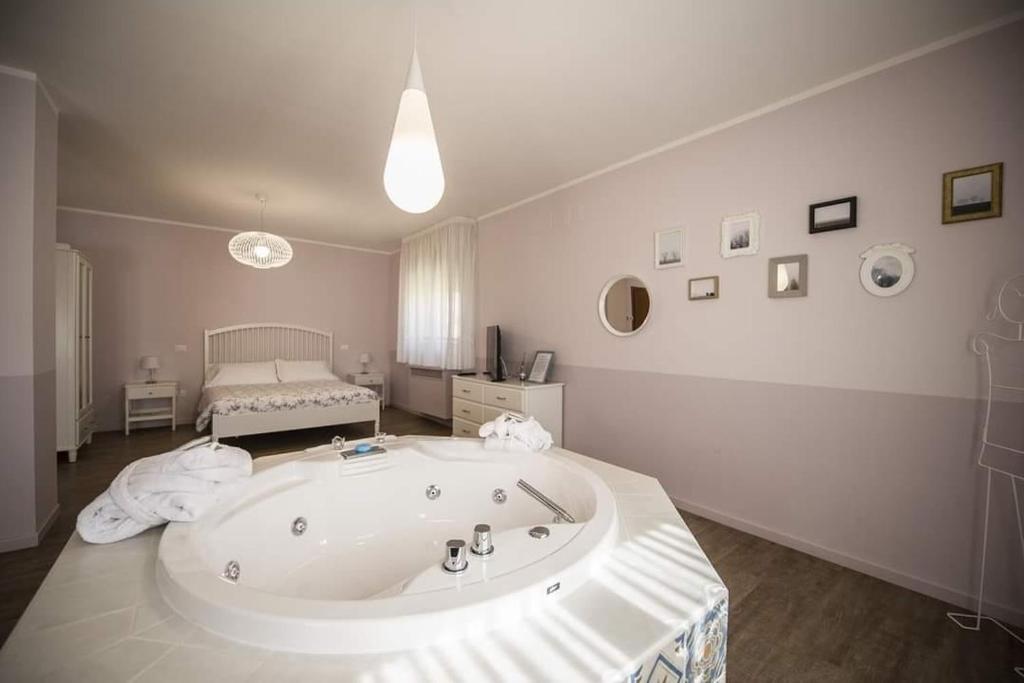 a large bath tub in a room with a bed at Agri Rio in Rio Salso Di Tavullia