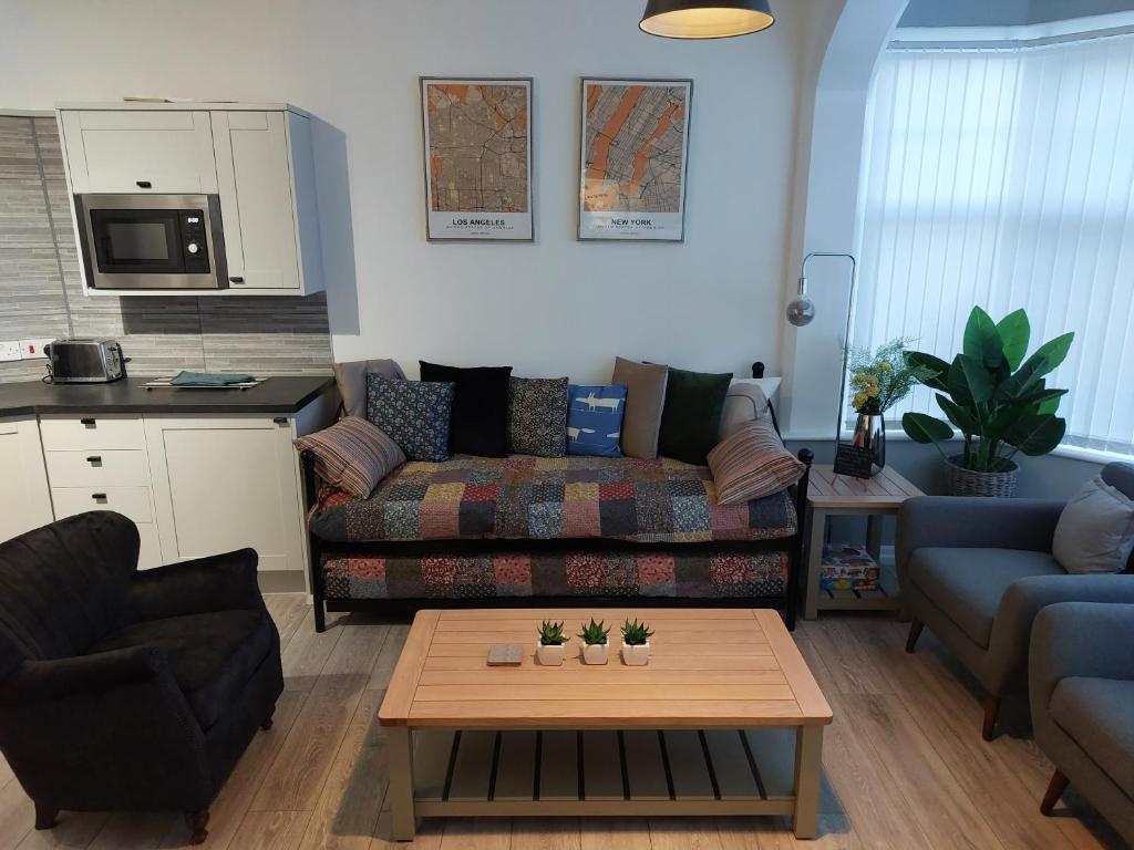 uma sala de estar com um sofá e uma mesa de centro em Flat 6 Corner House em Doncaster