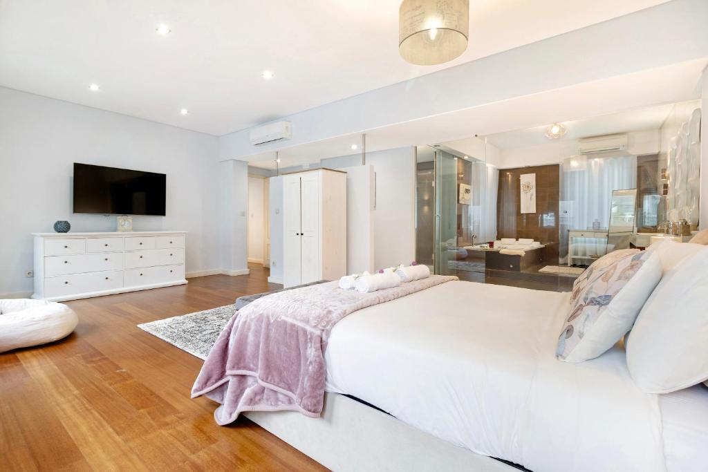 a white bedroom with a large bed and a bathroom at Apartment Boutique Santa Catarina 2 in Porto