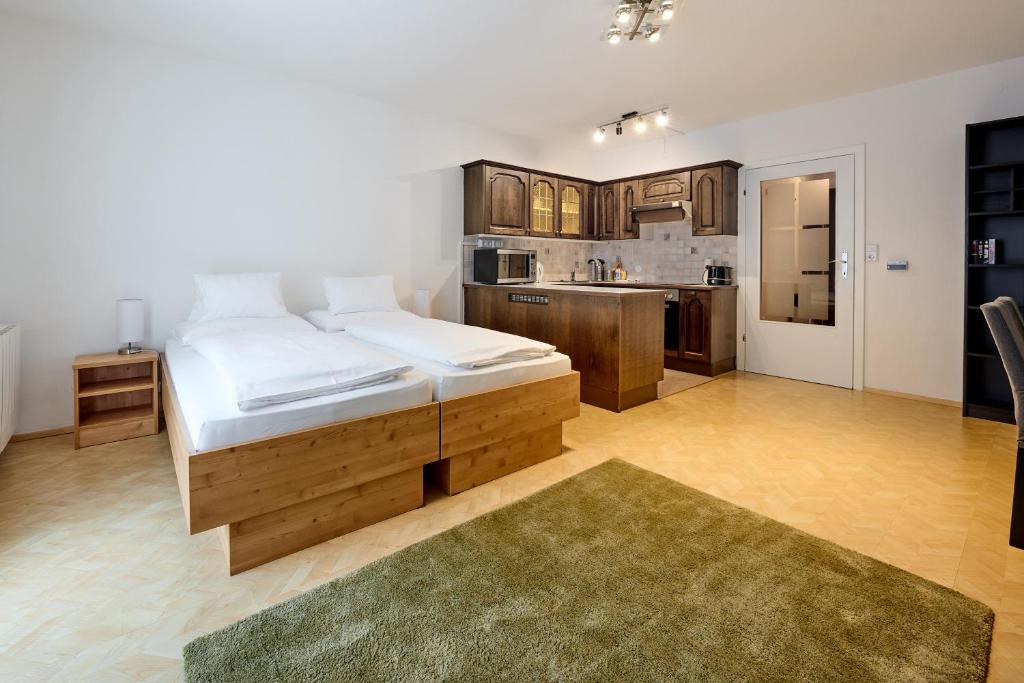 a bedroom with a large bed and a kitchen at Alpina Holiday Living Zirbenstrasse in Obertauern